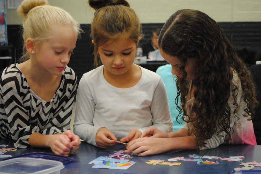 Doing a puzzle during morning hours of Metro, Fourth grader Mikayla Smith, Kindergartner Harmony Cook, and First grader Riley Gibson.